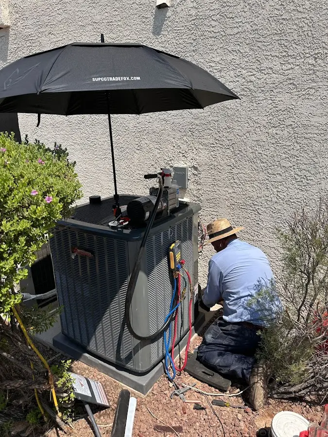 HVAC technician performing outdoor AC maintenance in Orchard Homes